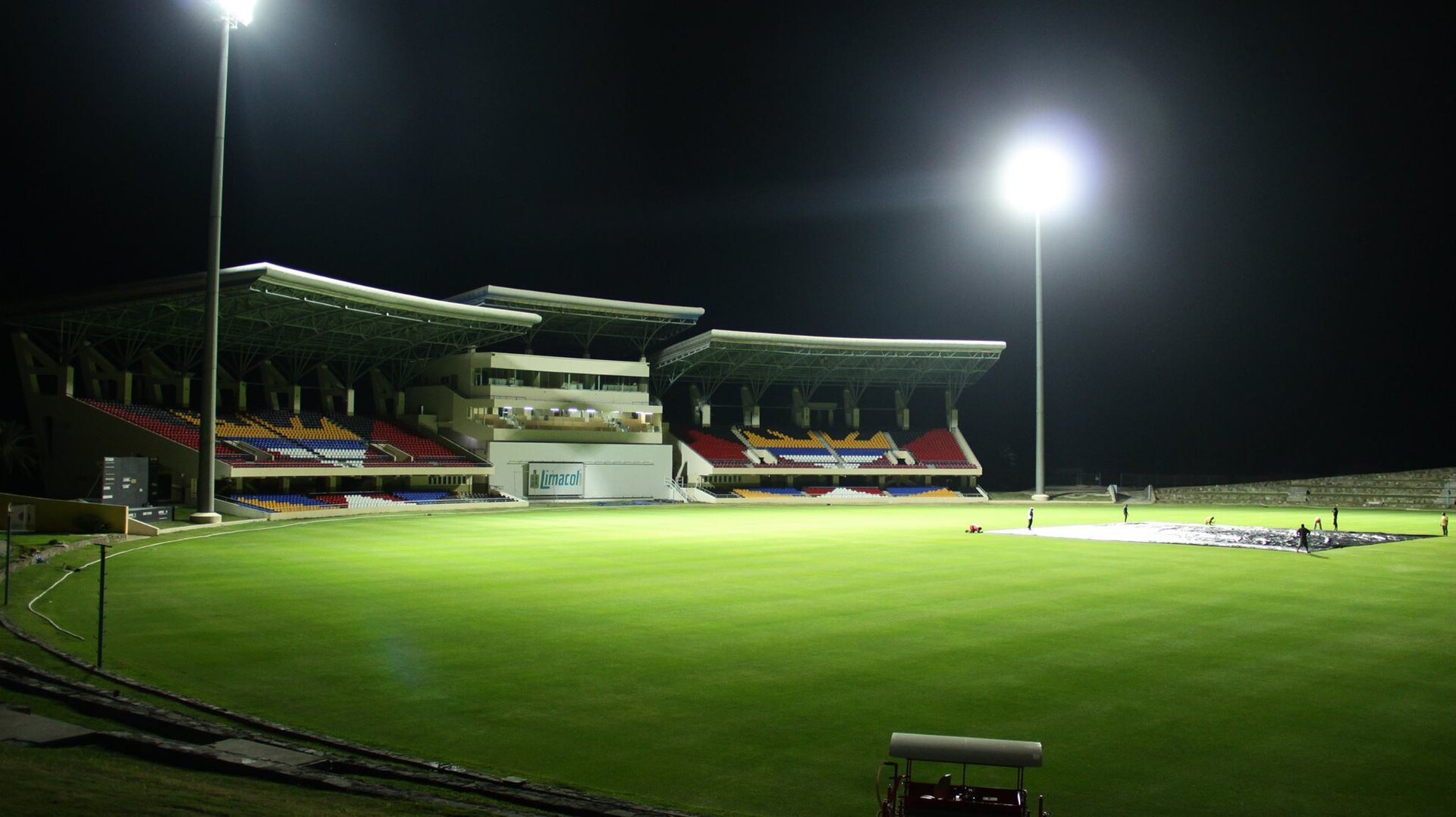 Sir Vivian Richards Stadium in Antigua under floodlights at night, with empty stands and a green outfield